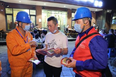 為各個攤位檢查用電安全情況、排查隱患、發(fā)放用電安全宣傳單